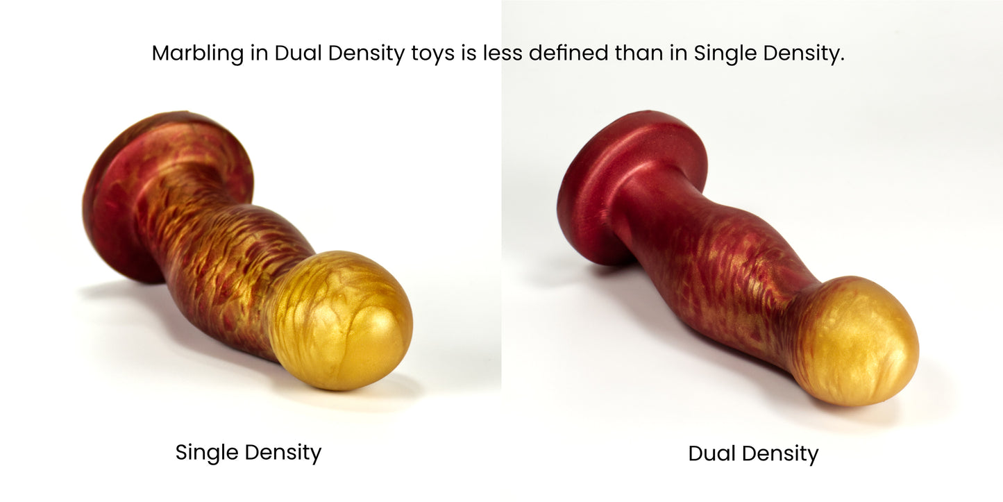 Two Ally dildos side by side. The left one has sharp, crisp marbled gold and red colors, and is labeled Single Density. The right has soft, feathery marbled gold and red colors and is labeled Dual Density. It is captioned: Marbling in Dual Density toys is less defined than in Single Density.