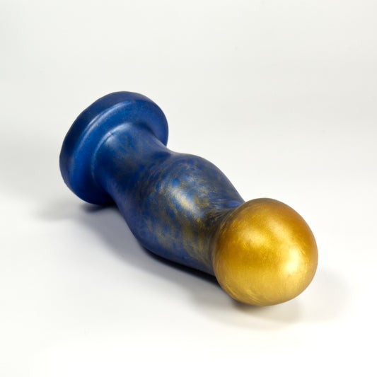Top view of the Ally Medium, a dildo shaped like a curved cylinder that flares out into pronounced bumps at the tip and center of the toy. Each bump has most of its volume towards the front of the toy, a little on the sides, and none on the back, which is smooth. The bumps are somewhat egg shaped.