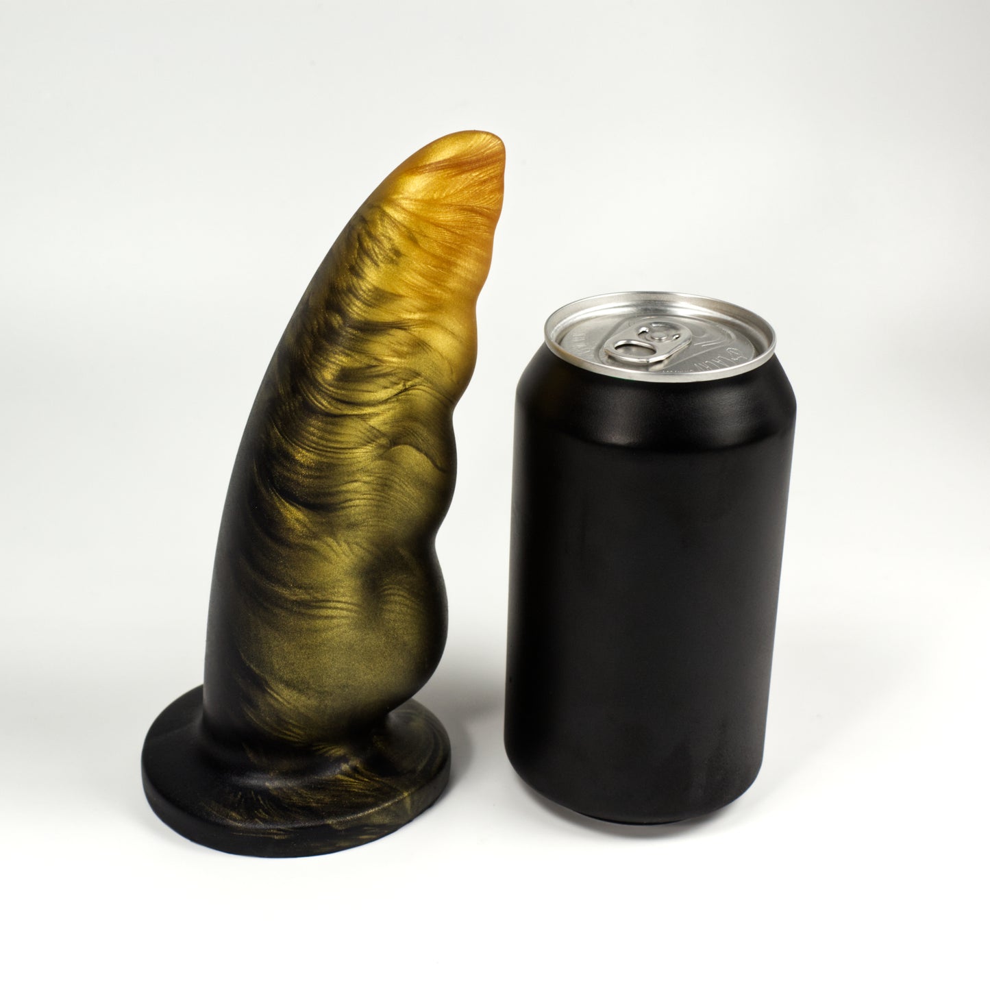 Side view of the Familiar next to a standard soda can, showing that the dildo is a few inches taller and tapers from about the same width as the can to about a quarter of its width.
