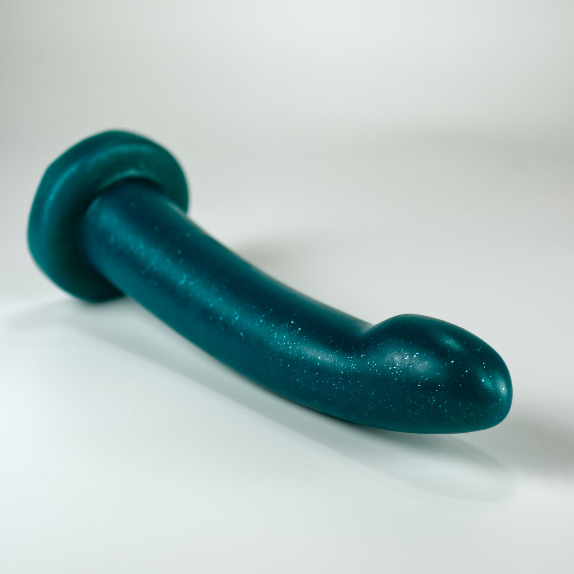 Top view of the Sidekick Extra Small, a dildo with a smooth cylinder shaped body, and a fingertip-shaped tip, and a pronounced cliff shape where they meet.