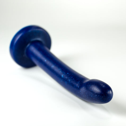 Top view of the Sidekick XXS, a dildo with a smooth cylinder shaped body, and a fingertip-shaped tip, and a pronounced cliff shape where they meet.